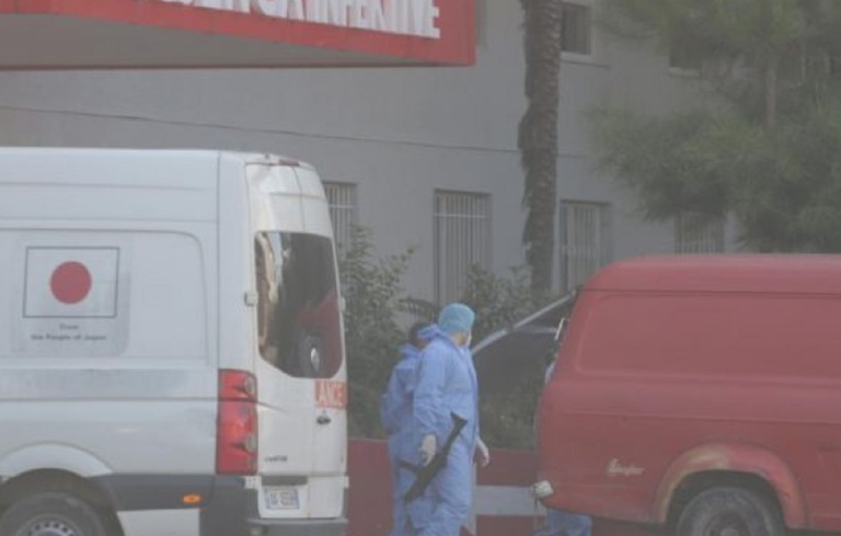 Ja si transportohet i burgosuri me COVID-19 tek infektivi, polici me veshje speciale dhe automatik në dorë